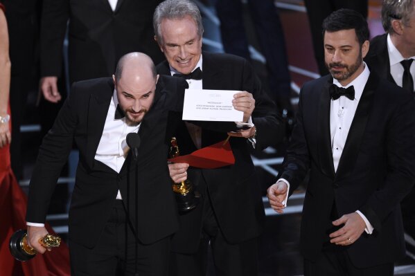 
              FILE - In this Feb. 26, 2017, file photo, Jordan Horowitz, producer of "La La Land," left, shows the envelope revealing "Moonlight" as the true winner of best picture at the Oscars in Los Angeles as presenter Warren Beatty and host Jimmy Kimmel, right, look on. The film academy and its accounting firm, PwC, are announcing a spate of new rules Monday, Jan. 22, 2018, meant to avoid an envelope gaffe like at last year’s show, when “La La Land” was mistakenly announced as the winner instead of “Moonlight.” PwC U.S. Chairman Tim Ryan said the new protocols include additional personnel and oversight, as well as practicing what to do if a presenter reads the wrong name. (Photo by Chris Pizzello/Invision/AP, File)
            