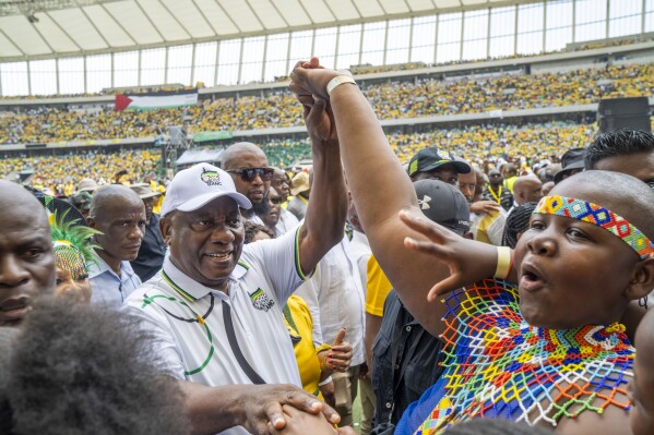 South African President Cyril Ramaphosa, centre left, is greeted by African National Congress supporters as he arrives at the Mose Mabhida stadium in Durban, South Africa, Saturday, Feb. 24, 2024, for the ANC national manifesto launch in anticipation of the 2024 general elections. (AP Photo/Jerome Delay)