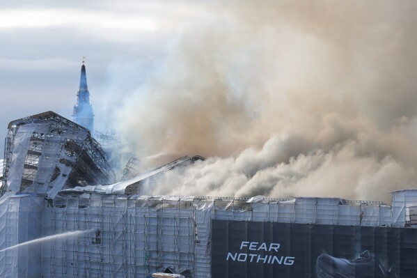 Smoke rises from the Old Stock Exchange, Boersen, in Copenhagen, Denmark, Tuesday, April 16, 2024. One of Copenhagen's oldest buildings is in flames and its iconic spire has collapsed.  The roof of the 17th-century Old Stock Exchange, or Boersen, which was once Denmark's financial center, was engulfed in flames on Tuesday.  (Emil Helms/Ritzau Scanpix via AP)