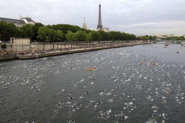 FILE - Competitors swim in the Seine River during the Paris Triathlon competition in Paris Sunday, July 10, 2011. Paris mayor Anne Hidalgo saidTuesday April 23, 2024 she was confident water quality will be up to the Olympics standards this summer _ and that she'll be able to prove it by swimming there, possibly alongside President Emmanuel Macron. (Ǻ Photo/Lionel Cironneau, File )
