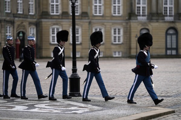 FILE -A changing of the guard at The Amalienborg Palace, home of the Danish Royal family in Copenhagen, Denmark Monday, Feb. 21, 2022. The Danish defense said Wednesday that they will remove the mandatory heights for men and women serving with the Danish Royal Life Guards, chiefly known for serving as a ceremonial unit outside Denmark’s royal palaces. (AP Photo/Alastair Grant, File)