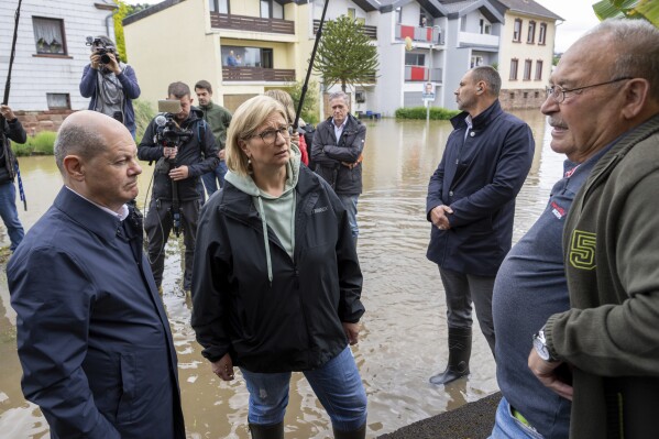 German Chancellor Olaf Scholz, left and Minister President Anke Rehlinger speak to local residents as they visit Kleinblittersdorf, Germany, which was hit by flooding, Saturday, May 18, 2024. Scholz has toured flooded regions in the southwest, where rivers have swelled and caused flash floods and landslides after heavy rain and severe weather. (Harald Tittel/dpa via AP)