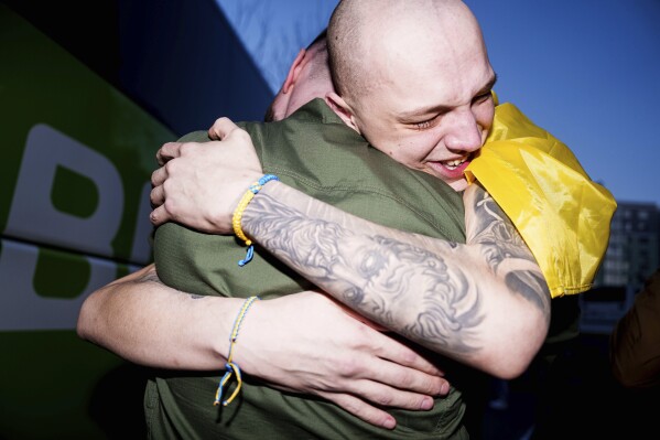 A Ukrainian soldier hugs his comrade after returning from captivity in a POW exchange in Ukraine, on Saturday, April. 19, 2025. (AP Photo/Evgeniy Maloletka)