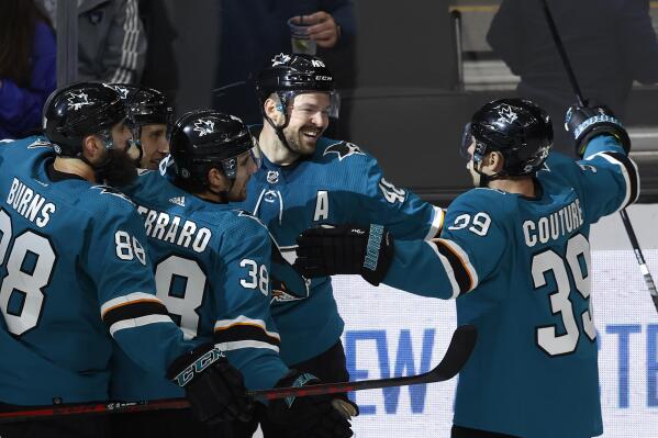 San Jose Sharks center Tomas Hertl, second from right, celebrates his goal against the Calgary Flames with defenseman Brent Burns (88), defenseman Mario Ferraro (38) and center Logan Couture, right, during the third period of an NHL hockey game Tuesday, Dec. 7, 2021, in San Jose, Calif. (AP Photo/Josie Lepe)