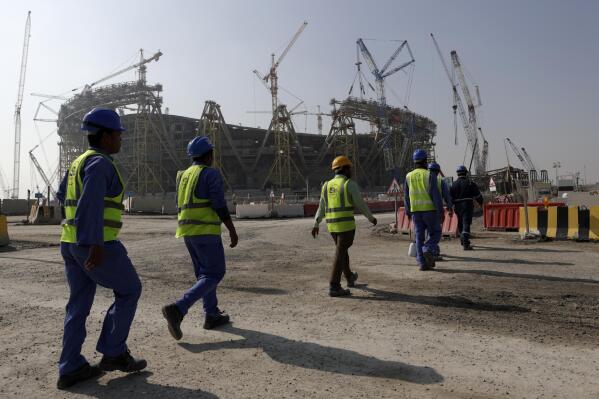FILE - Workers walk to the Lusail Stadium, one of the 2022 World Cup stadiums, in Lusail, Qatar, Friday, Dec. 20, 2019. Paris has decided not to display the matches of the World Cup in Qatar on giant screens in fan zones amid concerns over rights violations of migrant workers and the environmental impact of the tournament that have led some other French cities to make the same decision. (AP Photo/Hassan Ammar, File)