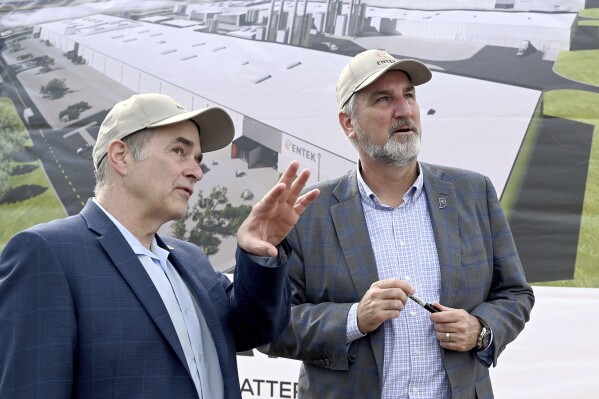 Larry Keith, CEO of ENTEK, points out one of the features in the artist's rendering of the new lithium battery separators plant to Gov. Eric Holcomb during the groundbreaking ceremony for the plant on Wednesday, Sept. 6, 2023 in Vigo County Industrial Park II near Terre Haute, Ind. (Joseph C. Garza/The Tribune-Star via AP)