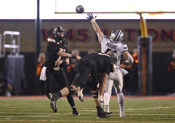 Oklahoma State offensive lineman <a href='/storiesByEntityId/6522fbe6d40b8ec4e3eedea8/Cole Birmingham' >Cole Birmingham</a> (67) runs behind Kansas State linebacker <a href='/storiesByEntityId/6522fbe6d40b8ec4e3eedead/Austin Moore' >Austin Moore</a> (41), who tries to deflect a pass thrown by Oklahoma State quarterback Alan Bowman (7) during the second half of an NCAA college football game Friday, Oct. 6, 2023, in Stillwater, Okla. Oklahoma State won 29-21. (AP Photo/<a href='/storiesByEntityId/6522fbe6d40b8ec4e3eedeb4/Brody Schmidt' >Brody Schmidt</a>)