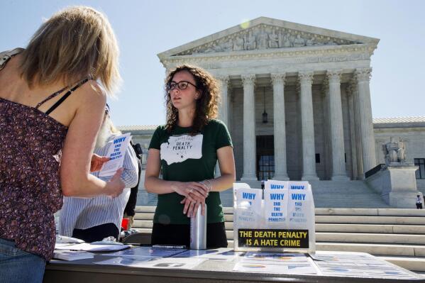 Danielle Fulfs, 24, of Seattle, with the Washington Coalition to Abolish the Death Penalty, hands out materials about the death penalty outside of the Supreme Court in Washington, Monday June 29, 2015. A deeply divided Supreme Court upheld the use of a controversial drug in lethal-injection executions Monday, even as two dissenting justices said for the first time they think it's "highly likely" the death penalty itself is unconstitutional.  (AP Photo/Jacquelyn Martin)