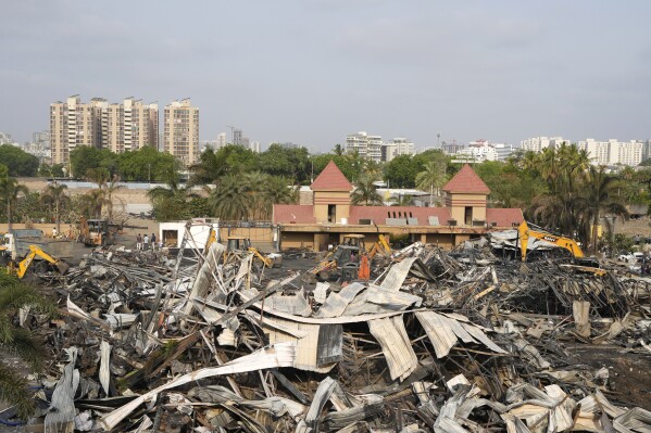 Earthmovers remove burnt debris the day after a fire broke out in an amusement park in Rajkot, India, Sunday, May 26, 2024. A massive fire damaged a large part of the park on Saturday, killing more than twenty people and injuring some others, news reports said. (AP Photo/Ajit Solanki)