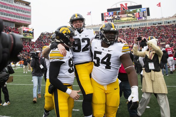 Iowa's Liam Reardon, left, and Anterio Thompson, right, carry kicker Marshall Meeder after he kicked a last-second field goal to defeat Nebraska 13-10 during an NCAA college football game, Friday, Nov. 24, 2023, in Lincoln, Neb. (AP Photo/Rebecca S. Gratz)