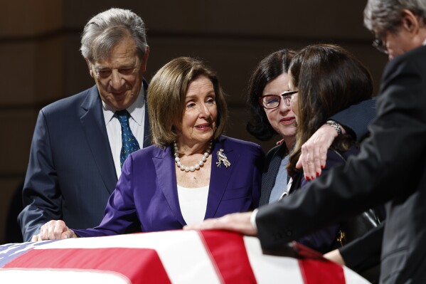 Former House Speaker Nancy Pelosi pays her respects to the late Senator Dianne Feinstein alongside her husband Paul Pelosi, left, and Dianne Feinstein's daughter Katherine Feinstein as her body lies in state in the Rotunda of City Hall in San Francisco, Calif. Wednesday, Oct. 4, 2023. (Jessica Christian/San Francisco Chronicle via AP)