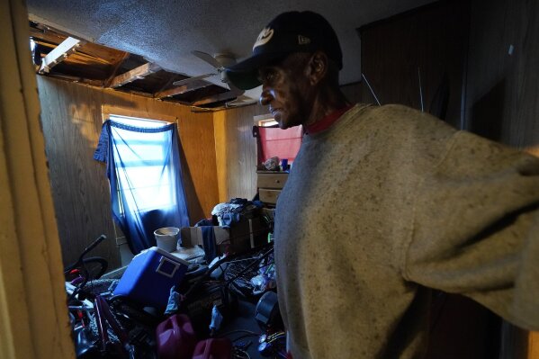 Ernest Jack moves through his home that was hit by Hurricane Laura ahead of Hurricane Delta, Friday, Oct. 9, 2020, in Lake Charles, La. Forecasters said Delta — the 25th named storm of an unprecedented Atlantic hurricane season — would likely crash ashore Friday evening somewhere on southwest Louisiana's coast. (AP Photo/Gerald Herbert)