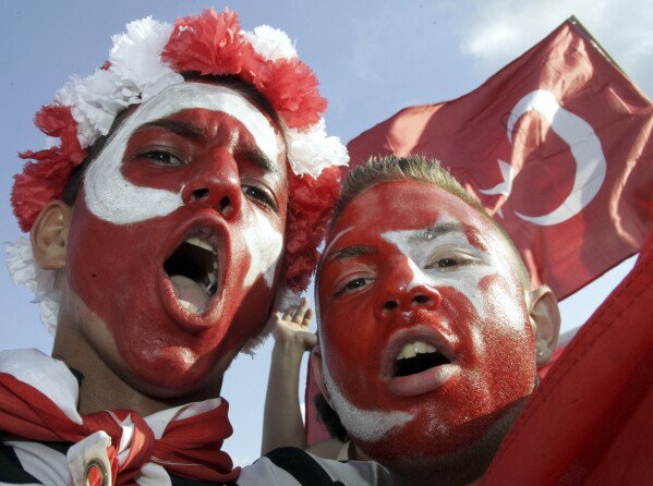 FILE -Turkey's fans celebrate at the KoelnArena-Dome prior to the soccer EURO 2008 semi-final match between Germany and Turkey in Cologne, western Germany, Thursday afternoon, June 25, 2008. “In Germany we’re going to be like a host country,” Turkey defender Ozan Kabak, who was born in Turkey but plays his club soccer in Germany, said in a recent interview. “A lot of Turkish people live here, and I think whole stadiums (are) going to be full of Turkish people." Fans of the Turkish team even outnumbered Germany’s supporters at the friendly in Berlin last year. (AP Photo/Roberto Pfeil, File)