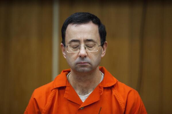 FILE - In this Feb. 5, 2018, file photo, Larry Nassar, former sports doctor who admitted molesting some of the nation's top gymnasts, appears in Eaton County Court in Charlotte, Mich.  The U.S. Department of Justice on Tuesday said it is reviewing an earlier decision to decline prosecution against two former FBI agents embroiled in the Larry Nassar sexual abuse cases after new information has emerged.  While testifying before the Senate Judiciary Committee, Deputy Attorney General Lisa Monaco said the newly confirmed assistant attorney general for the department’s criminal division will be taking a second look at the FBI’s alleged failure to promptly address complaints made in 2015 against Nassar.(Matthew Dae Smith/Lansing State Journal via AP, File)