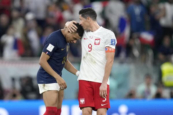 France's Kylian Mbappe, left, and Poland's Robert Lewandowski, right, speak after the World Cup round of 16 soccer match between France and Poland, at the Al Thumama Stadium in Doha, Qatar, Sunday, Dec. 4, 2022. (AP Photo/Natacha Pisarenko)