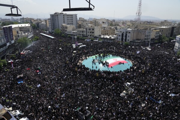 Iranians attend a funeral ceremony for the late President Ebrahim Raisi and his companions who were killed during a helicopter crash on Sunday in a mountainous region of the country's northwest, in Tehran, Iran, Wednesday, May 22, 2024. (AP Photo/Vahid Salemi)