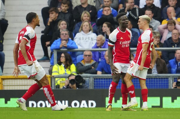 Arsenal's Leandro Trossard, right, celebrates after scoring his side's opening goal during the English Premier League soccer match between Everton and Arsenal at the Goodison Park stadium in Liverpool, England, Sunday, Sept. 17, 2023. (AP Photo/Jon Super)