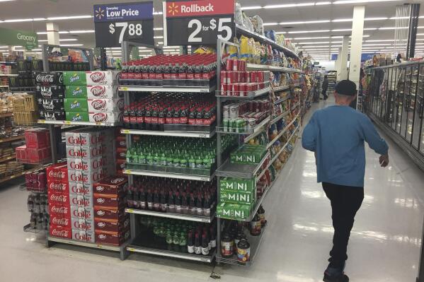 FILE - In this April 15, 2017 photo, a shopper walks among stacks of discount soda at a Walmart story in Santa Fe, N.M. The U.S. Supreme Court has declined to hear a challenge to Santa Fe campaign disclosure requirements stemming from a failed city ballot initiative in 2017 to tax sugary beverages. The Supreme Court decision Monday, April 18, 2022, upholds the rejection of a lawsuit from the Rio Grande Foundation that sought to shield future financial contributions from public disclosure, in defiance of requirements enacted by the city of Santa Fe. (AP Photo/Morgan Lee,File)