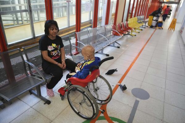 Lucia Ruiz Diaz sits next to her 5-year-old son Tomas, who has cancer, at a waiting room in the Garrahan Hospital in Buenos Aires, Argentina, Tuesday, April 29, 2025. Cancer patients say they’ve grown sicker since Argentina’s libertarian President Javier Milei took his chainsaw to the public health system. (AP Photo/Natacha Pisarenko)