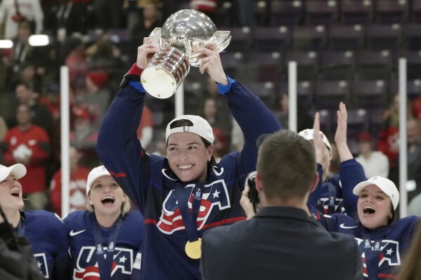 FILE - United States forward Hilary Knight, center, holds the cup as she celebrates with teammates after defeating Canada in the gold medal game at the women's world hockey championships in Brampton, Ontario, April 16, 2023. Patience remains the operative word from United States star Knight on the Professional Women’s Hockey Players’ Association’s long-awaited bid to launch its own pro league. (Nathan Denette/The Canadian Press via AP, File)