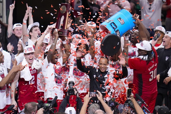 FILE - North Carolina State's DJ Burns Jr. (30) dumps confetti on head coach Kevin Keatts following an Elite Eight college basketball game against Duke in the NCAA Tournament in Dallas, Sunday, March 31, 2024. N.C. State’s men’s basketball team is in the Final Four for the first time since 1983, while the Wolfpack women are in the Final Four for the first time since 1998. (AP Photo/LM Otero, File)