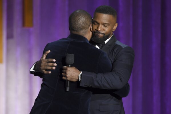 Eddie Murphy, left, and Jamie Foxx hug on stage at the Governors Awards on Sunday, Oct. 27, 2019, at the Dolby Ballroom in Los Angeles. (Photo by Chris Pizzello/Invision/AP)