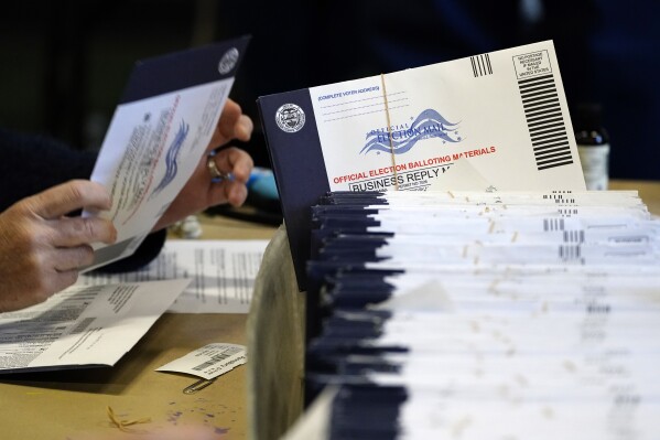 FILE - Chester County, Pa. election workers process mail-in and absentee ballots at West Chester University in West Chester on Nov. 4, 2020. Law enforcement agencies, civil defense officials and election administrators have begun meeting in Pennsylvania to coordinate how they will identify and fight election threats with the presidential contest just eight months away in the battleground state, Gov. Josh Shapiro’s administration said Thursday, Feb. 29, 2024. (AP Photo/Matt Slocum, File)