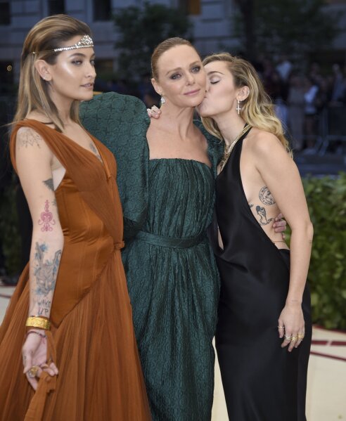 
              Paris Jackson,from left, Stella McCartney and Miley Cyrus attend The Metropolitan Museum of Art's Costume Institute benefit gala celebrating the opening of the Heavenly Bodies: Fashion and the Catholic Imagination exhibition on Monday, May 7, 2018, in New York. (Photo by Evan Agostini/Invision/AP)
            