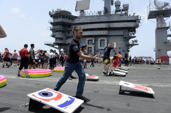 In this June 6, 2020, photo provided by the U.S. Navy, sailors participate in sporting events on the flight deck of the aircraft carrier USS Dwight D. Eisenhower (CVN 69). When coronavirus made U.S. Navy ship stops in foreign countries too risky, the USS Dwight D Eisenhower and the USS San Jacinto were ordered to keep moving, and avoid all port visits. More than five months after they set sail, they have broken a record they never planned to achieve. As they steamed through the North Arabian Sea on June 25, they notched their 161st consecutive day at sea, breaking the previous Navy record of 160 days.  (Mass Communication Specialist Seaman Brennen Easter/U.S. Navy via AP)