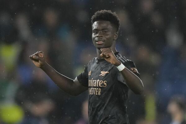 Arsenal's Bukayo Saka celebrates after the end of the English Premier League soccer match between Brighton and Hove Albion and Arsenal and at the AMEX Community Stadium in Brighton, England, Saturday, Dec. 31, 2022. Arsenal won the game 4-2.(AP Photo/Alastair Grant)