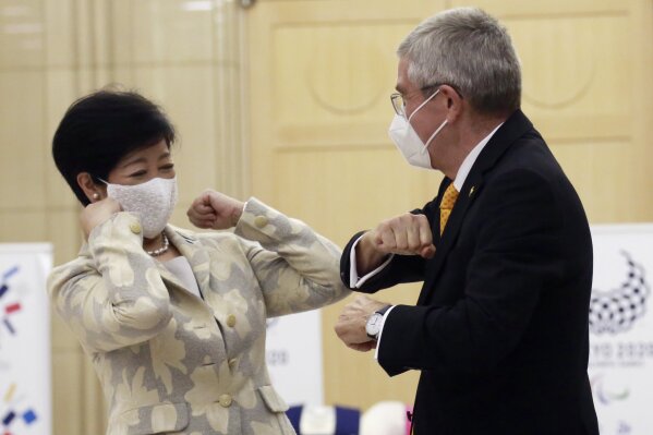 Tokyo Governor Yuriko Koike, left, greets International Olympic Committee President Thomas Bach before their meeting in Tokyo, Monday, Nov. 16, 2020. IOC President Bach is beginning a visit to Tokyo to convince politicians and the Japanese public that the postponed Olympics will open in just over eight months.(AP Photo/Koji Sasahara)