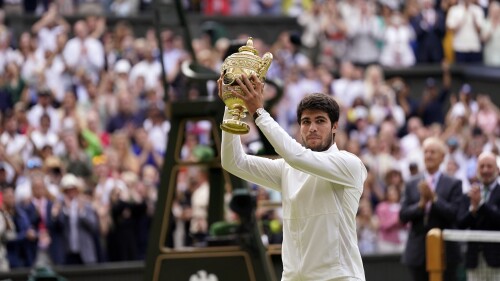 Spain's Carlos Alcaraz celebrates with his trophy after beating Serbia's Novak Djokovic in the men's singles final on day fourteen of the Wimbledon tennis championships in London, Sunday, July 16, 2023. (AP Photo/Alberto Pezzali)