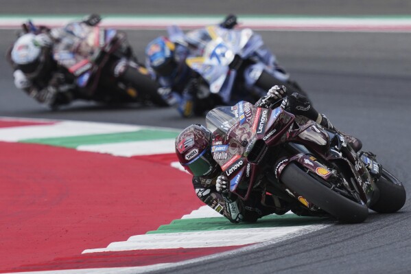 Spain's rider Marc Marquez of the Ducati Lenovo Team steers his motorcycle followed by Spain's rider Alex Marquez of the BK8 Gresini Racing MotoGP and Italian rider Francesco Bagnaia of the Ducati Lenovo Team during the MotoGP race of the Grand Prix of Italy at the Mugello circuit in Scarperia, Italy, Sunday, June 22, 2025. (AP Photo/Antonio Calanni)