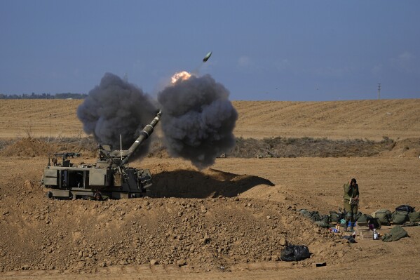 An Israeli mobile artillery unit fires a shell from southern Israel towards the Gaza Strip, in a position near the Israel-Gaza border, Israel, Sunday, Oct. 15, 2023. (AP Photo/Ohad Zwigenberg)