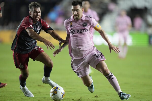 Inter Miami forward Lionel Messi, right, takes the ball past Toronto FC defender Kobe Franklin during the first half of an MLS soccer match, Wednesday, Sept. 20, 2023, in Fort Lauderdale, Fla. (AP Photo/Wilfredo Lee)