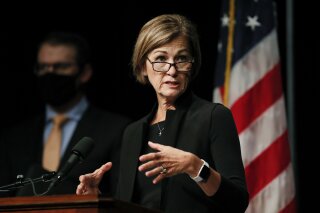 FILE - In this Aug. 4, 2020 file photo, Iowa Gov. Kim Reynolds updates the state's response to the coronavirus outbreak during a news conference in Johnston, Iowa. The refusal of Gov. Reynolds to require Iowans to wear masks in public has prompted at least three cities and a county to impose their own local ordinances setting up what could be a legal battle over whether local officials have the authority to impose such demands. (AP Photo/Charlie Neibergall, File)