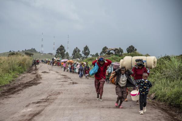 People walk on the road near Kibumba, north of Goma, Democratic Republic of Congo, as they flee fighting between Congolese forces and M23 rebels in North Kivu, Tuesday May 24, 2022. Congolese authorities have accused Rwandan forces of supporting armed groups in mineral-rich eastern Congo, where dozens of such groups are active. Rwanda has described allegations of supporting rebels in Congo as baseless. (AP Photo/Moses Sawasawa)