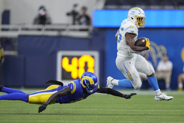 Los Angeles Chargers running back Joshua Kelley, right, jumps past Los Angeles Rams cornerback Robert Rochell during the first half of a preseason NFL football game Saturday, Aug. 12, 2023, in Inglewood, Calif. (AP Photo/Mark J. Terrill)