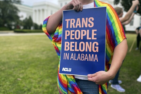 FILE - A person holds up a sign reading, "Trans People Belong in Alabama," during a rally outside the Alabama Statehouse in Montgomery, Ala., on International Transgender Day of Visibility, Friday, March 31, 2023. On Monday, Aug. 21, 2023, a federal appeals court ruled that Alabama can enforce a ban outlawing the use of puberty blockers and hormones to treat transgender children, the second such appellate victory for gender-affirming care restrictions that have been adopted by a growing number of Republican-led states. (AP Photo/Kim Chandler, File)
