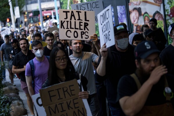 Protesters march through downtown Seattle after body camera footage was released of a Seattle police officer joking about the death of Jaahnavi Kandula, a 23-year-old woman hit and killed in January by officer Kevin Dave in a police cruiser, Thursday, Sept. 14, 2023, in Seattle. (AP Photo/Lindsey Wasson)