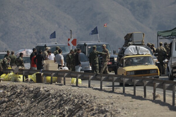 Ethnic Armenians from Nagorno-Karabakh and European Union observers drive their cars past a check point on the road from Nagorno-Karabakh to Armenia's Goris in Syunik region, Armenia, Friday, Sept. 29, 2023. Armenian officials say more than 70% of Nagorno-Karabakh's original population have fled the region for Armenia. (AP Photo/Vasily Krestyaninov)