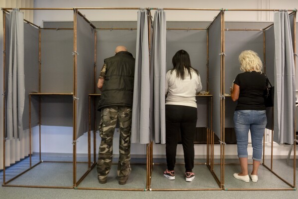 Voters fill in their ballot papers at a polling station during the European Parliament and the local elections in Salgotarjan, Hungary, Sunday, June 9, 2024. (Peter Komka/MTI via AP)