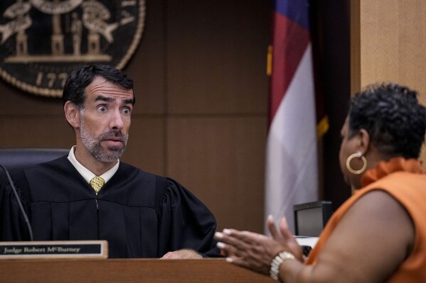 County Clerk Che Alexander, right speaks with Fulton County Superior Court Judge Robert McBurney, Monday, Aug. 14, 2023, in Atlanta. (AP Photo/Brynn Anderson)