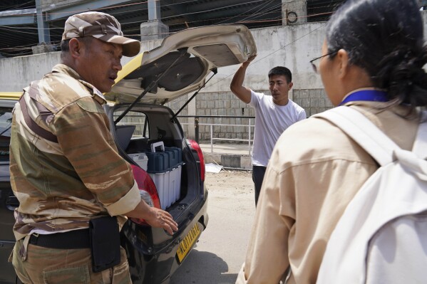 A police officer speaks with polling officer Neke W Konyak, 29, after loading electronic voting machine and other related election material, before proceeding towards their polling station in Kohima, in the northeastern Indian state of Nagaland, Thursday, April 18, 2024. (AP Photo/Yirmiyan Arthur)