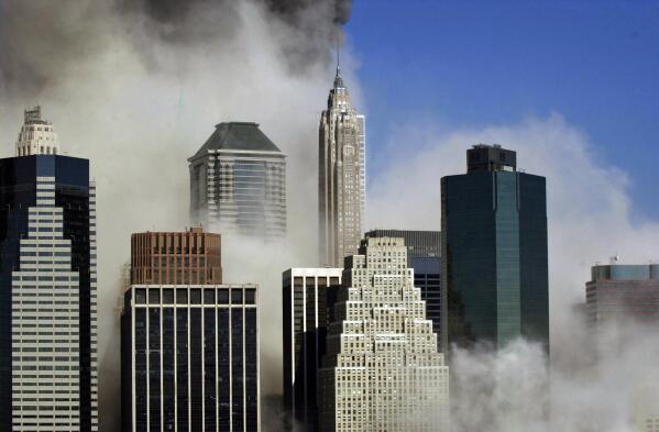 Smoke billows through buildings in Manhattan as seen from Brooklyn after the collapse of New York's World Trade Center, Tuesday, Sept. 11, 2001. (AP Photo/Kathy Willens)