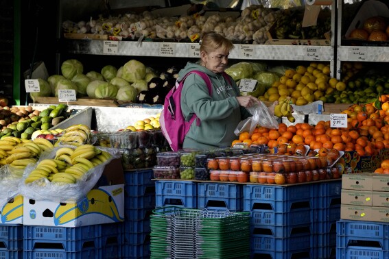 FILE - A woman selects fruits at a supermarket in London, on Nov. 17, 2021. Inflation in the U.K. fell to its lowest level in two and a half years in March after a further easing in food prices, official figures showed Wednesday, April 17, 2024. (AP Photo/Frank Augstein, File)