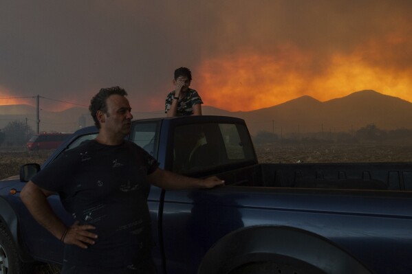 Local residents watch a wildfire in Avantas village, near Alexandroupolis, Greece, Aug. 21, 2023. (AP Photo/Achilleas Chiras)