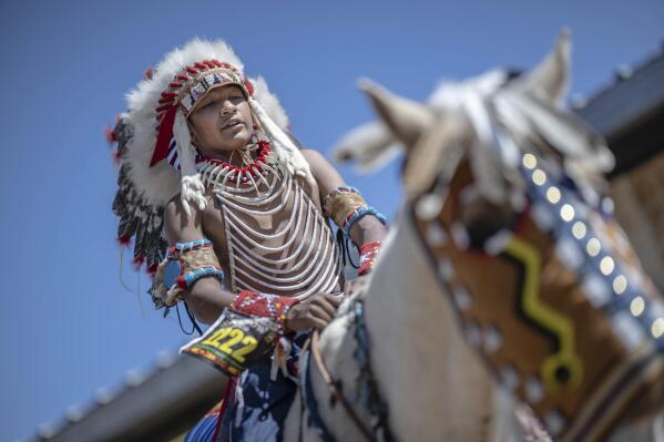 Fourteen year-old Mylan Archuleta of Ohkay Owingeh village in northern New Mexico prepares to ride his horse in the horse parade at the 40th anniversary of the Gathering of Nations Pow Wow in Albuquerque, N.M., Friday, April 28, 2023. Tens of thousands of people gathered in New Mexico on Friday for what organizers bill as the largest powwow in North America. (AP Photo/Roberto E. Rosales)