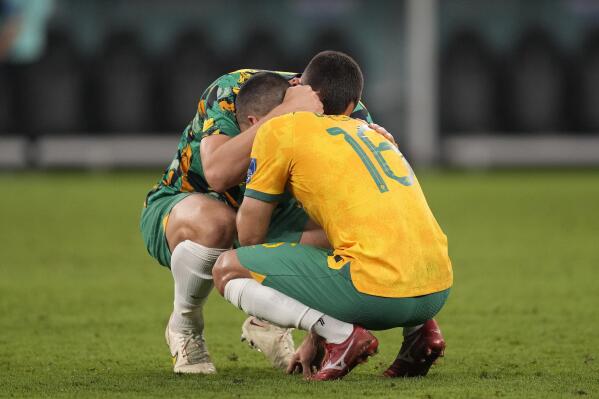 Australia's Aziz Behich is comforted after losing the World Cup round of 16 soccer match between Argentina and Australia at the Ahmad Bin Ali Stadium in Doha, Qatar, Saturday, Dec. 3, 2022. (AP Photo/Lee Jin-man)