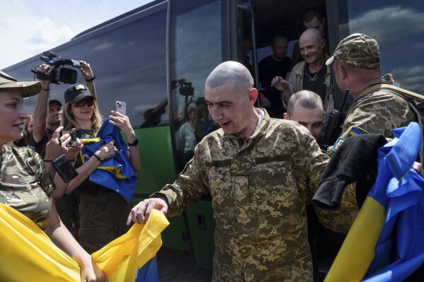 A Ukrainian serviceman reacts after returning from captivity during POWs exchange in Sumy region, Ukraine, Friday, May 31, 2024. Ukraine returned 75 prisoners, including four civilians, in the latest exchange of POWs with Russia. It's the fourth prisoner swap this year, and 52nd since Russia invaded Ukraine. In all, 3 210 Ukrainian servicemen and civilians were returned since the outbreak of the war. (AP Photo/Evgeniy Maloletka)